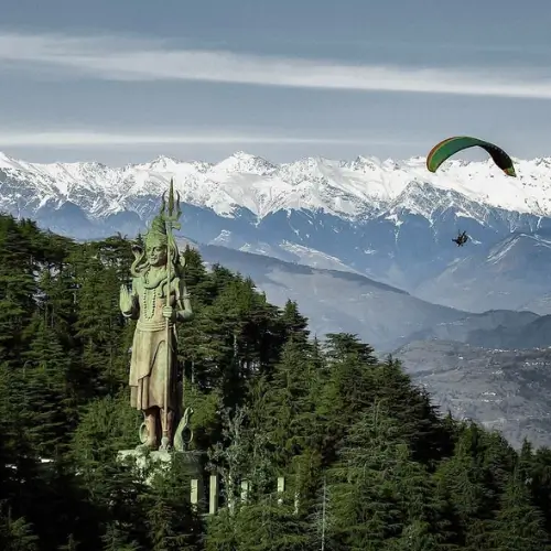 Khajjiar shiv statue with distinct paragliding in the mountains